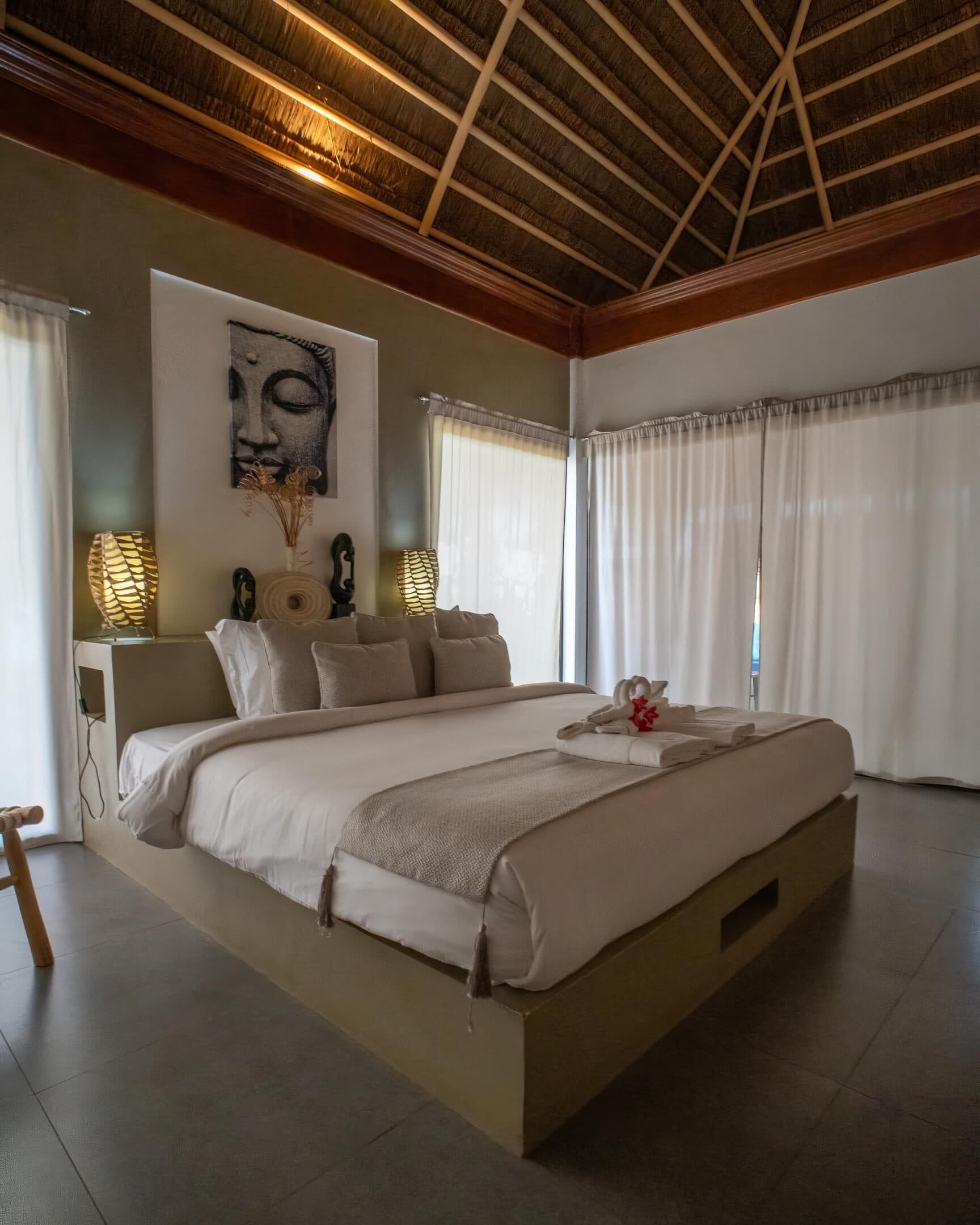 Garden Villa bedroom under a vaulted thatch roof